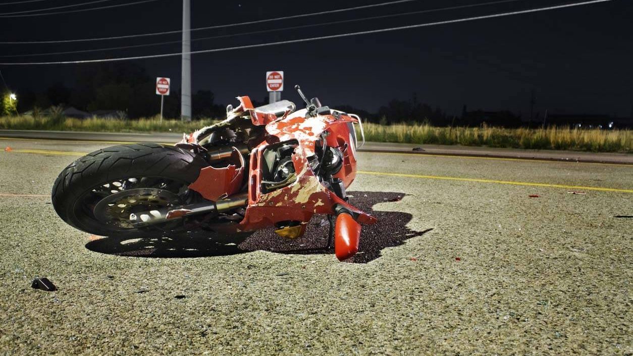 a motorcycle laying on the road with damages after a motorcycle accident