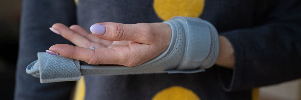 a woman's hand wrapped in a brace because of a personal injury 