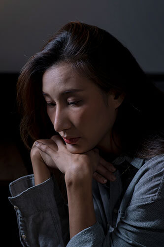 a woman wondering how to file a personal injury lawsuit with her head resting on her hands