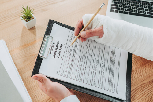 Injured worker signing workers' comp agreement.